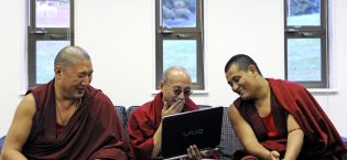 On a break for tea, Tibetan Buddhist monks Yeshi Tsultrim (left), Tenzin (center) and Kalsang Gyatso laugh at a video on a laptop in the Houston memorial Chapel at Randolph College in Lynchburg, Va., October 24, 2011.
  (Photo by Parker Michels-Boyce/The News & Advance)